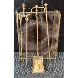A brass and wire fire screen with a set of brass companion set.