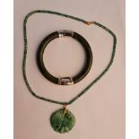 A green hardstone pendant on link chain along with a bangle with safety chain