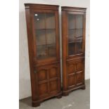 A pair of distressed oak glazed topped corner cabinets.