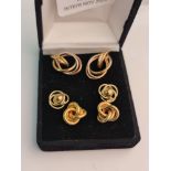 Three pairs of yellow metal knot design earrings.