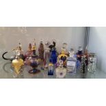 A collection of glass perfume bottles and glass duck.