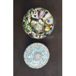A glass millefiori paperweight together with a CC paperweight.