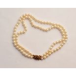 A double row string of pearls, with hallmarked 9ct yellow gold and gem stone clasp