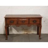 A distressed oak dresser base with three drawers.