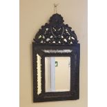 A bronze framed wall mirror with berry and leaf design.