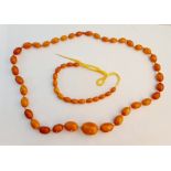 A string of graduated butterscotch amber beads together with part string of butterscotch amber