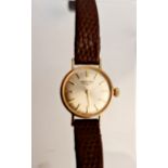 A 9ct yellow gold cased Longines wrist watch, on a brown strap.