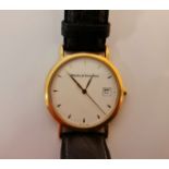 A Watches of Switzerland wrist watch, unmarked yellow metal, on a black strap.