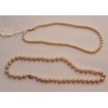 A string of simulated pearls on yellow metal clasp along with a string of cultured pearls on clasp