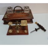 A oak desktop inkwell set of brass scales and corkscrew.