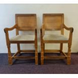 A pair of Robert Thompson Mouseman oak carved dining chairs.
