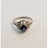 A sapphire and diamond tiered cluster ring, set with a central oval cut sapphire, surrounded by