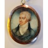 A Georgian portrait miniature on ivory a gentleman in gilt metal oval frame and plaited hair