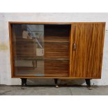 A walnut bookcase with two glass sliding doors.