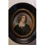 A 19th century portrait miniature on ivory of a lady in mourning dress in oval wooden frame. This
