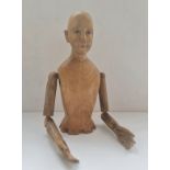 A carved wooden mannequin doll with glass eyes top half height 33 cm.