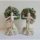 A pair of Derby Chelsea porcelain figures cherubs with flower baskets.