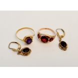 A yellow metal ring of three graduated red stones, ring size K, and a yellow metal gem stone ring,