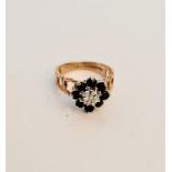 A hallmarked 9ct yellow gold black sapphire cluster ring, with central diamond accent, ring size