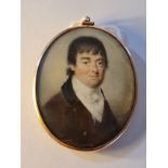 An early 19th century portrait miniature on ivory of a Georgian gentleman in brown coat in gold