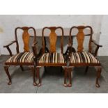 A reproduction mahogany and walnut dining table and four chairs and two carvers with brass inlay