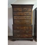 An early 19th century oak eight drawer chest on chest with inlay to side and top on bracket feet