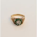 A hallmarked 9ct yellow gold emerald cluster ring with central diamond accent, ring size L,