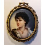 A portrait miniature on ceramic oval of a youth with black hair and open shirt with jewelled