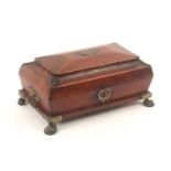 A Regency red leather sewing box, circa 1815, of sarcophagol form raised on brass paw feet, leaf