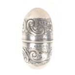 A silver egg form sewing compendium, decorated with flowers and 'C' scrolls, unscrewing to reveal