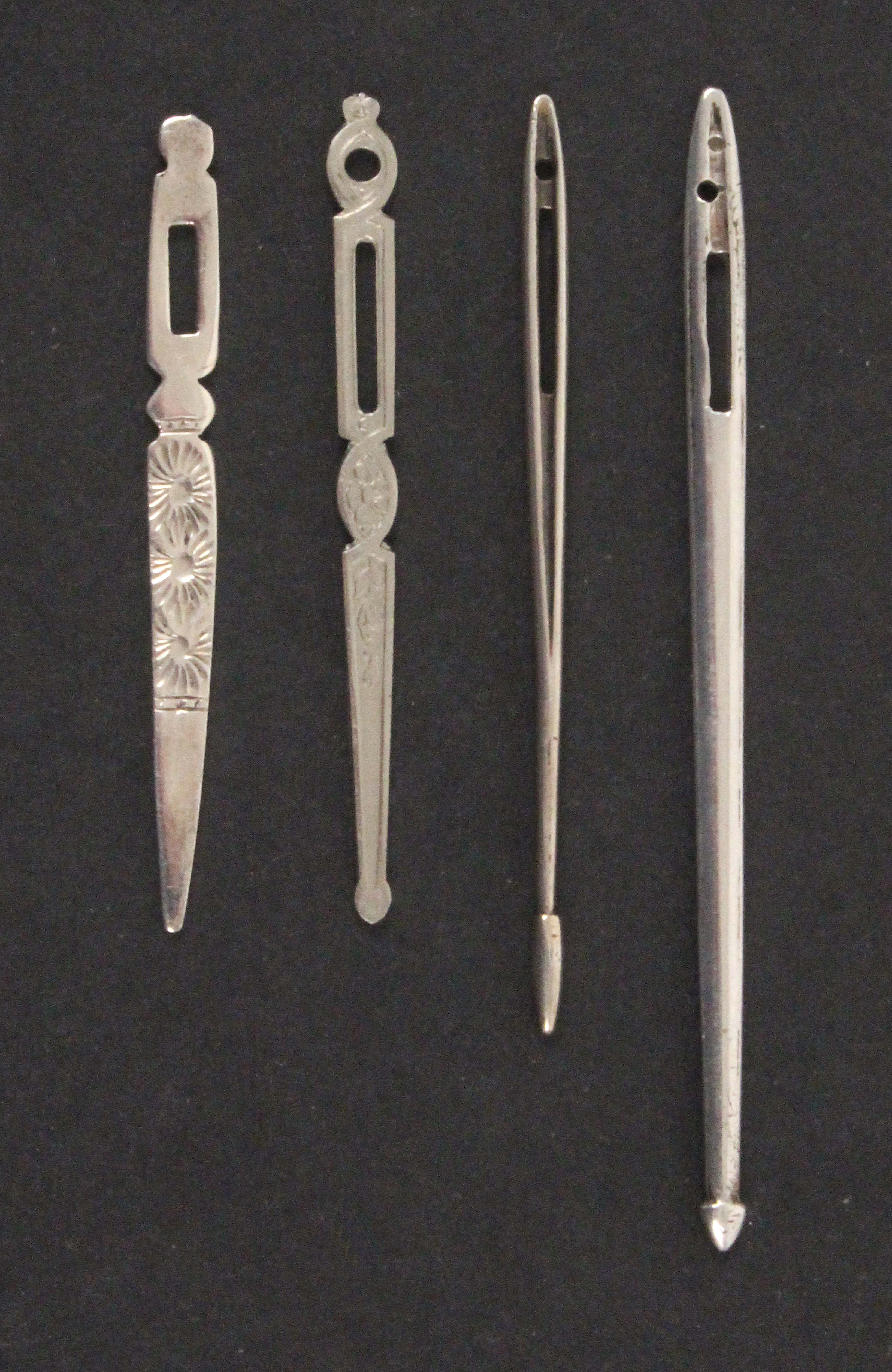 Four silver bodkins, comprising two 19th Century English fish form examples, largest 7.2cms, a