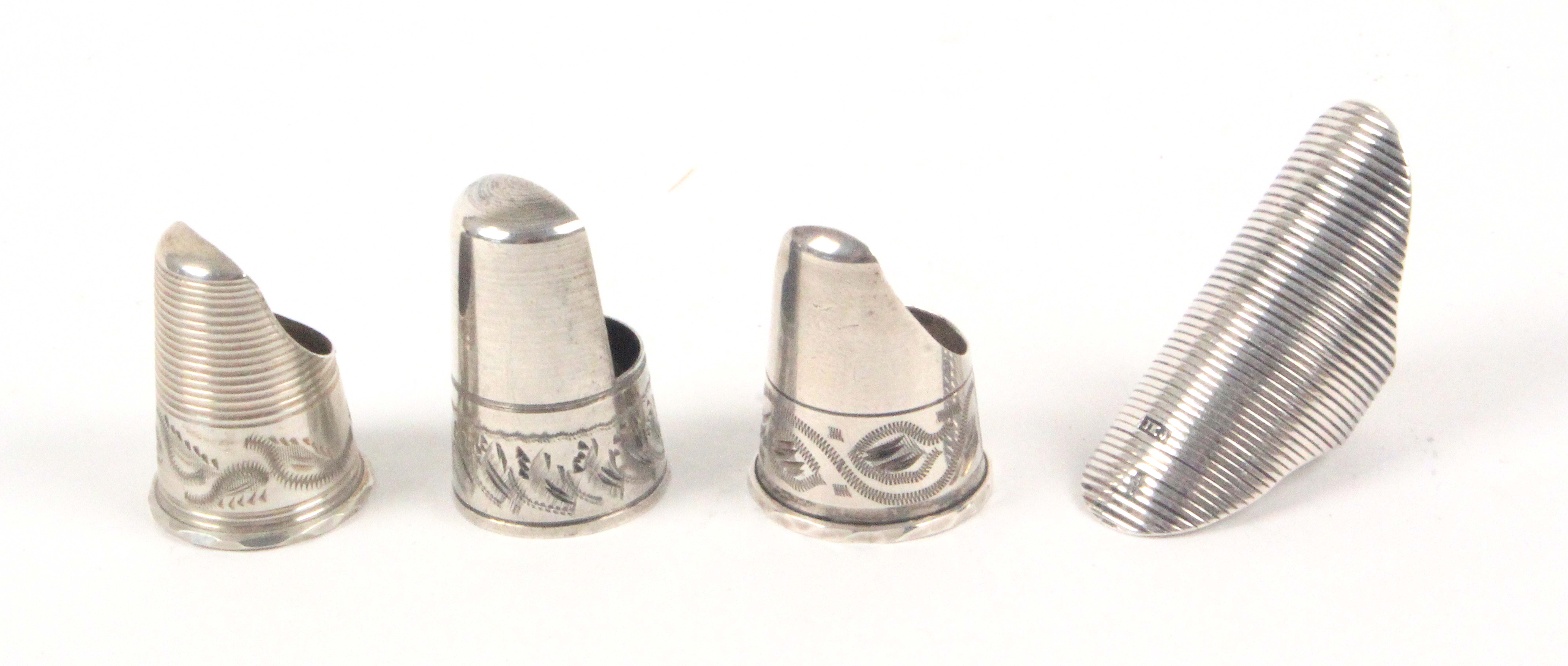 Four silver thimbles, comprising a ribbed Dutch finger ring with makers mark 'J.K.A.', and three