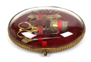 A French gilt metal mounted glass cased sewing set for a child or doll, circa 1860, of oval form