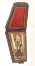 A scarce miniature etui for a doll, circa 1840, the gilt tooled leather case of tapering form, the