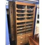 A haberdashery/shop fitting, with two rows of sixteen drawers, below four short drawers, with