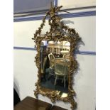 A large ornate carved pine decorative mirror, surmounted by an eagle with acanthus and scrolls,