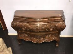 A Continental style walnut bombe commode chest, with carved drawers, 130cm wide