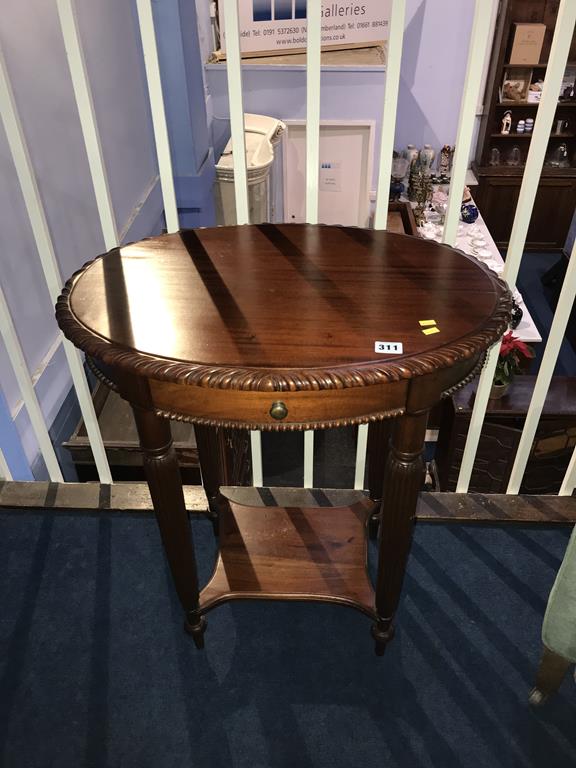 A reproduction mahogany oval side table