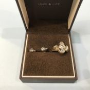 An 18ct gold ring set with three diamonds, central stone 0.57ct and a pair of diamond earrings