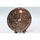A polished circular fossilized frosterley marble plate