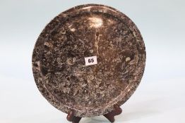 A polished circular fossilized frosterley marble plate