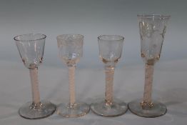 A 19th century engraved opaque air twist wine glass and three other opaque air twist glasses