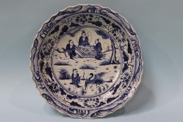 A large Oriental blue and white circular shallow dish, decorated with cranes and figures, 39cm