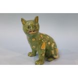 An Emile Galle style pottery cat, with glass eyes, on green ground with yellow hearts, 20cm height