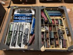 Two trays of model train engines and rolling stock