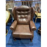A brown leather wing armchair