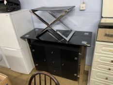 A chrome and leather top stool and a glass top cabinet