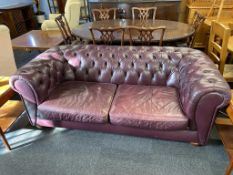 A maroon leather Chesterfield two seater sofa