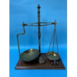 A pair of Victorian brass balance scales and weights on mahogany base