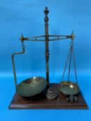 A pair of Victorian brass balance scales and weights on mahogany base